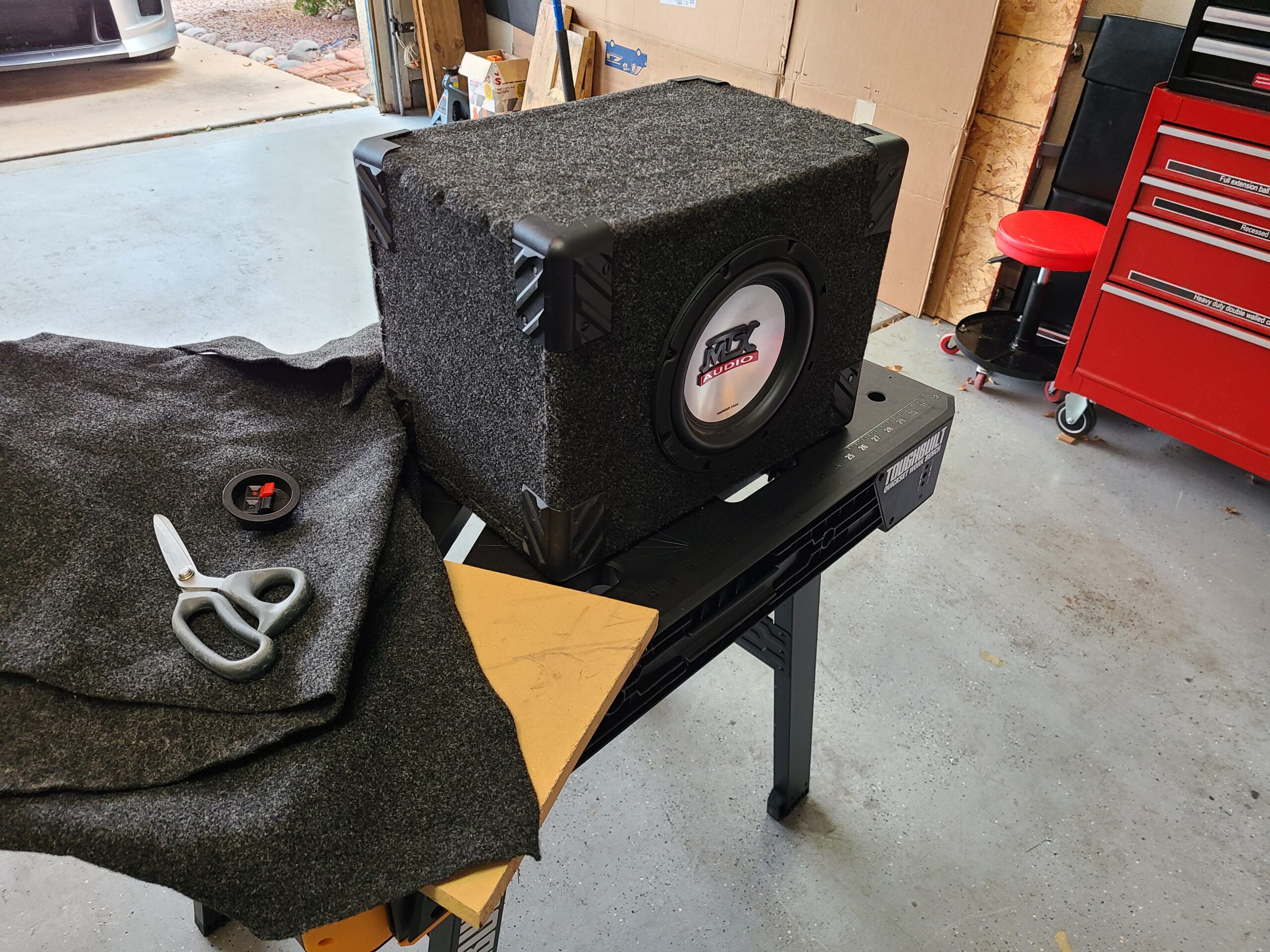 Vehicle subwoofer on workbench with building materials